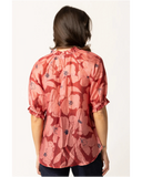 Back view of the Seeking Lola Essence Top in Pink Bloom, displaying the smooth drape and premium pattern continuation. A woman viewed from the back wearing a short-sleeve blouse with a red and pink floral pattern and dark blue jeans, set against a plain white background.