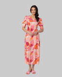 Seeking Lola Florence Dress in Strawberry Punch front view showing the elegant relaxed midi length silhouette flattering tailored V-neckline and clean casual flowing lower pink hemline profile, sold by Point Break Cambridge local family surf shop at 63 Duke street.