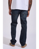 Back view of the Volcom Solver Modern Fit Denim Jeans in New Vintage Blue wash showcasing the signature asymmetric yoke and stone embroidery on the pocket.