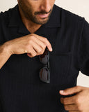 Model wearing the Rhythm Textured Knit Whip Stitch Polo - Black on a plain background