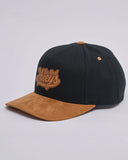The Mad Hueys Ball Twill Snapback in Black side profile view showing the clean crown alignment and stitched ventilation eyelets, sold by Point Break Cambridge local family surf shop at 63 Duke street.