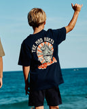 The Mad Hueys Godzilla Forever Youth SS Tee in Navy blue back view showing the relaxed straight kids silhouette and bold oversized custom monster fish monster artwork graphic print, sold by Point Break Cambridge local family surf shop at 63 Duke street.