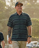The Mad Hueys Hueys Stripe SS Woven Shirt in Pine Green close up view highlighting the premium rayon fabric texture chest pocket label and integrated bottle opener patch, sold by Point Break Cambridge local family surf shop at 63 Duke street.