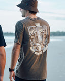 The Mad Hueys Scootin Shoey SS Tee in Walnut Washed brown back view showing the relaxed straight silhouette and bold oversized custom shoey graphic artwork print, sold by Point Break Cambridge local family surf shop at 63 Duke street.