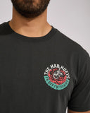 The Mad Hueys Shield Fk Off SS Tee in Vintage Black close up view highlighting the premium soft cotton knit fabric weave texture and high density screen print graphic finish detail, sold by Point Break Cambridge local family surf shop at 63 Duke street.