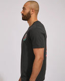 The Mad Hueys Shield Fk Off SS Tee in Vintage Black side profile view showing the comfortable casual short sleeve length and clean flat stitched hemline alignment, sold by Point Break Cambridge local family surf shop at 63 Duke street.