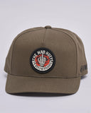 he Mad Hueys Shield Fk Off Twill Snapback in Olive green front view showing the structured crown and custom shield graphic embroidery, sold by Point Break Cambridge local family surf shop at 63 Duke street.
