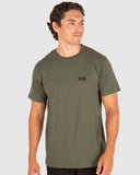 Man wearing a green t-shirt with a small logo on a light gray background