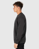 Unit Unisex Central Crew in Washed Black side profile view showing the comfortable sleeve drape depth and snug ribbed wrist cuff layout, sold by Point Break Cambridge local family surf shop at 63 Duke street.