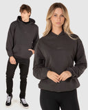 Unit Unisex Central Hoodie in Washed Black front view showing the comfortable pullover hood design spacious kangaroo pocket and bold front graphic logo print, sold by Point Break Cambridge local family surf shop at 63 Duke street.