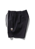 Black athletic shorts with an elastic waistband and drawstring, featuring a small black and white embroidered logo on the left leg, shown on a white background. Vissla Solid Sets 17.5" Ecolastic Short - Black