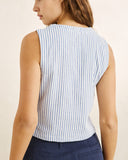 A woman shown from the back wearing a sleeveless top with vertical light blue and white stripes, paired with navy pants, against a plain light beige background. Rhythm Vista Stripe Vest Blue