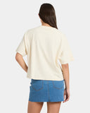 Person wearing a light yellow oversized t-shirt and blue denim skirt on a white background