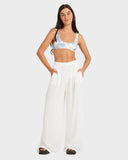Woman wearing a floral top and white pants on a plain background Volcom Make Us Shine Tank Bikini Top - Bay Blue