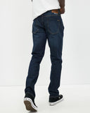 Back view of the Volcom Vorta Denim Slim Fit Jeans in New Vintage Blue showcasing the signature asymmetric yoke and embroidered rear pockets.