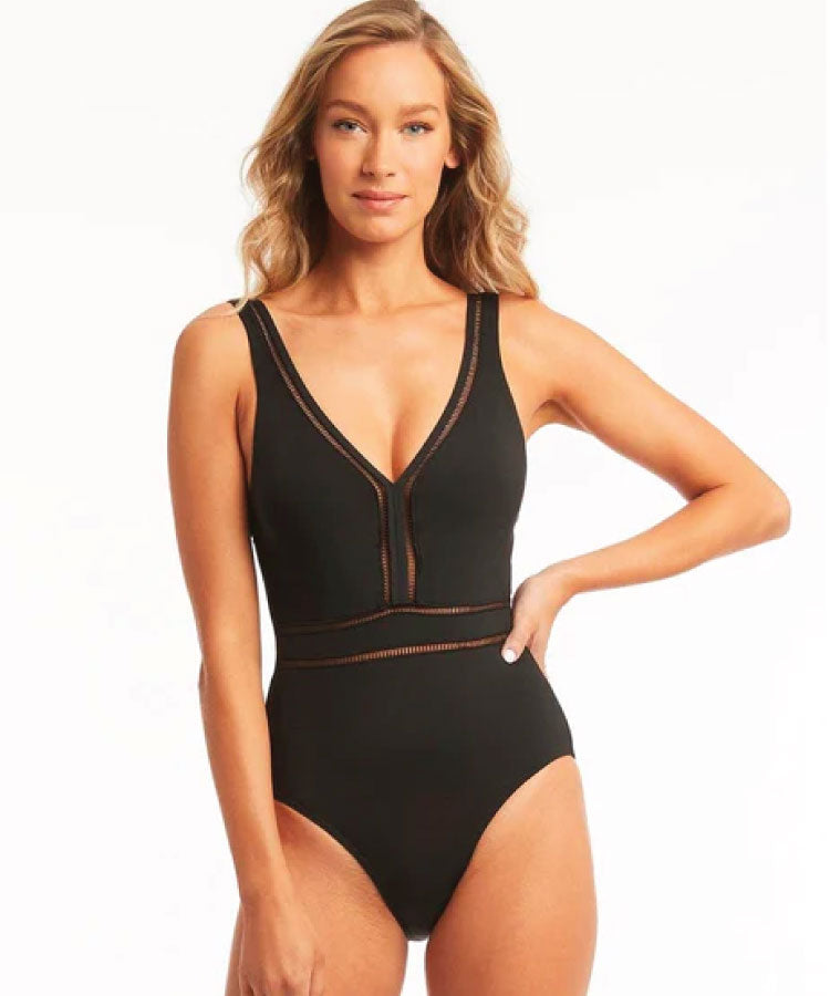 Close up shot of model wearing Sea Level Eco Essentials Spliced Waisted One Piece Swimsuit - Black on a white background.