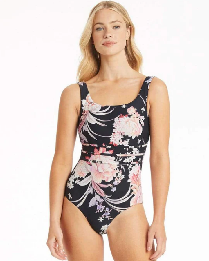 A woman wearing a black one-piece swimsuit with a soft floral pattern, featuring a square neck and scoop back design. Sea Level Square Neck Scoop Back One Piece Martini swimsuit - Black