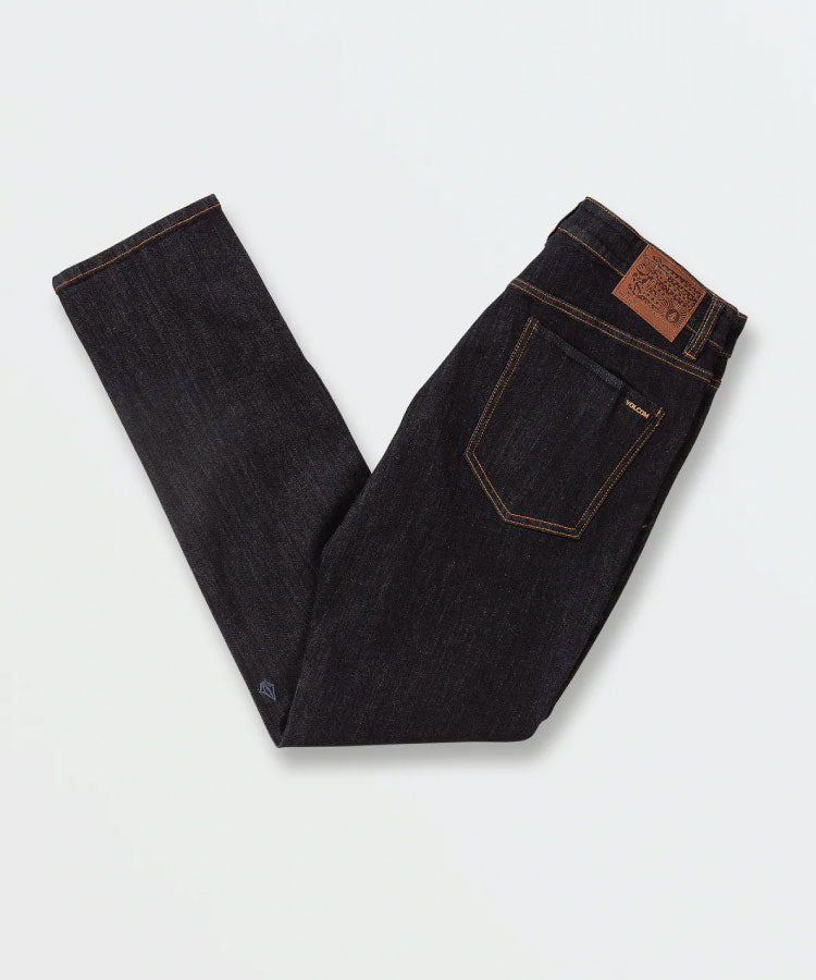 Close up detail of the vintage blue indigo wash, heavy-duty pocket rivets, and custom Volcom metal button.