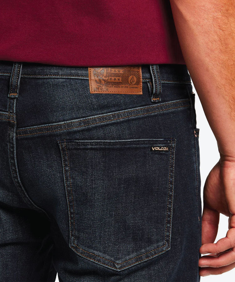 Close up detail of the vintage blue indigo wash, heavy-duty pocket rivets, and custom Volcom metal button.