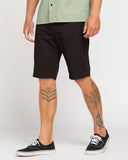model wearing volcom solver lite 5 pocket mens shorts showing the knee length fit.